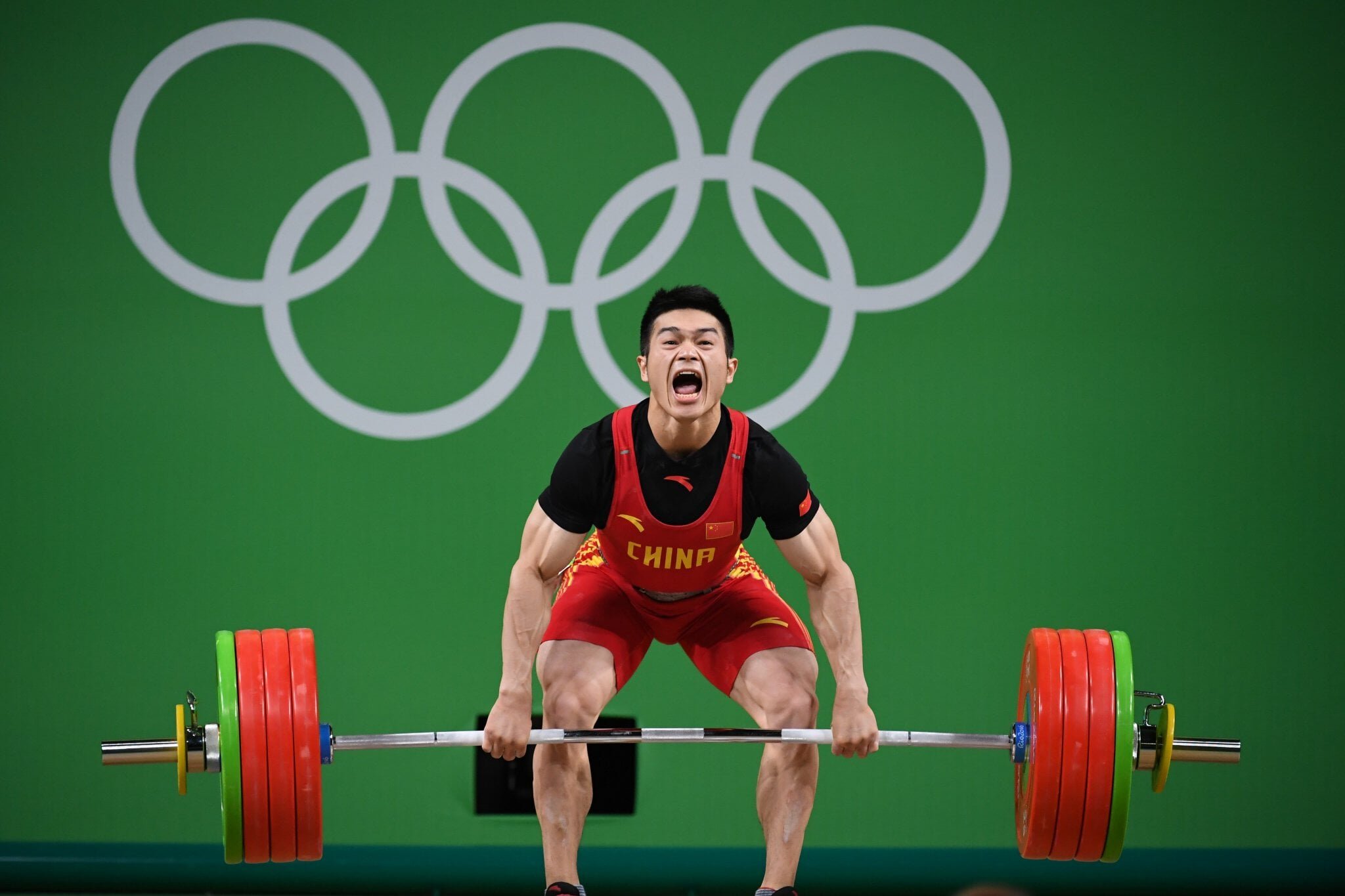 Спортсмены на соревнованиях по тяжелой атлетике. Ши Чжиюн тяжелая атлетика. Shi Zhiyong тяжелая атлетика. Люй Сяоцзюнь тяжелая атлетика. Китайский тяжелоатлет Люй Сяоцзюнь.