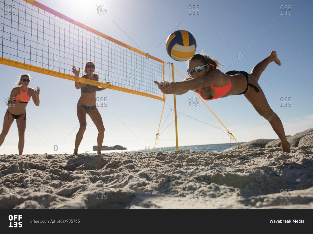 Девушки играющие в волейбол на пляже